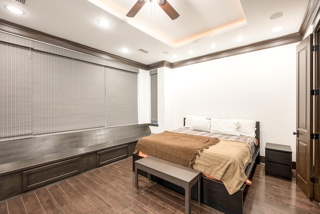 bedroom with ceiling fan, recessed lighting, dark wood-type flooring, a raised ceiling, and crown molding