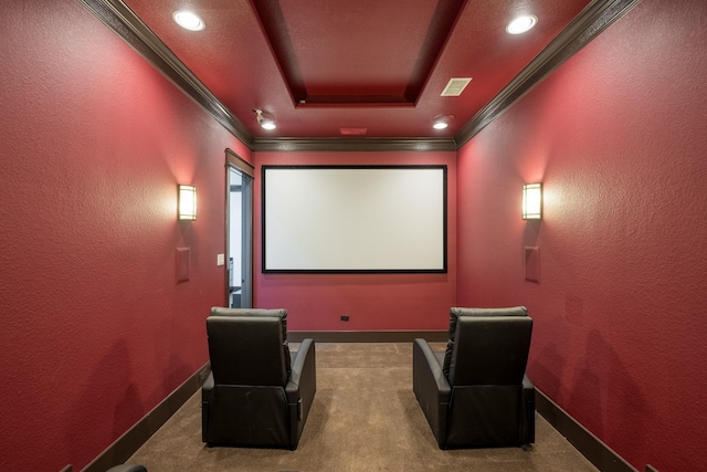 home theater room featuring baseboards, a textured wall, carpet, a tray ceiling, and crown molding