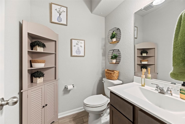 bathroom with hardwood / wood-style flooring, vanity, and toilet