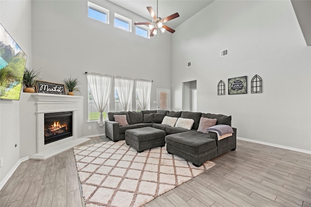 living room with light hardwood / wood-style flooring, ceiling fan, and plenty of natural light