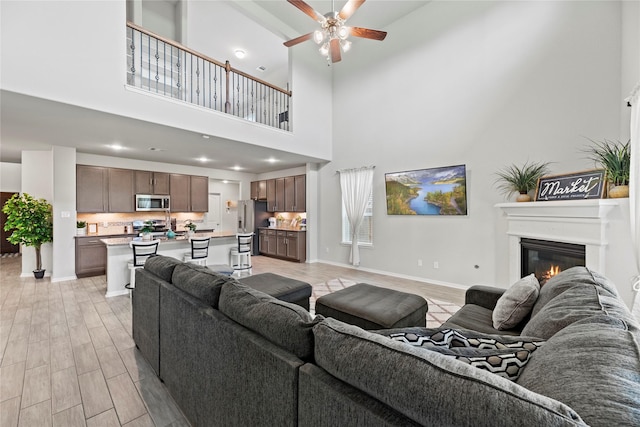 living room featuring ceiling fan and light wood-type flooring