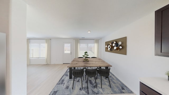 dining area with plenty of natural light and light wood-style flooring