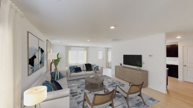 living area featuring light wood-style flooring and recessed lighting