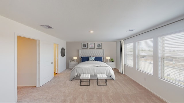 bedroom featuring visible vents, light carpet, and baseboards