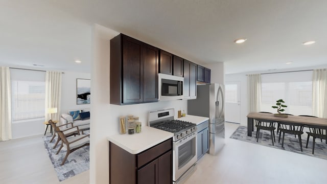 kitchen featuring dark brown cabinets, stainless steel appliances, light countertops, and recessed lighting