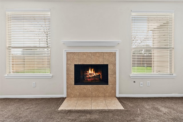 room details featuring a tile fireplace and carpet