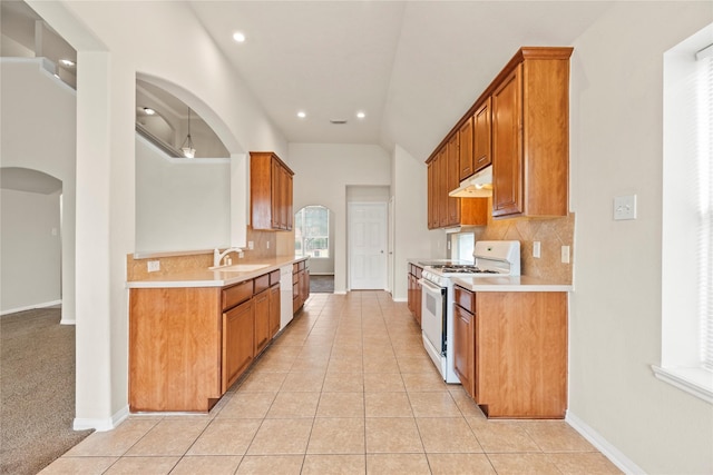 kitchen featuring light tile patterned flooring, lofted ceiling, sink, tasteful backsplash, and white appliances