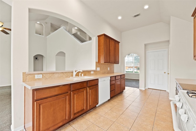 kitchen with sink, decorative backsplash, light tile patterned floors, ceiling fan, and white appliances