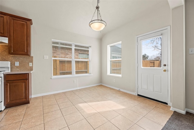 unfurnished dining area featuring light tile patterned floors and vaulted ceiling