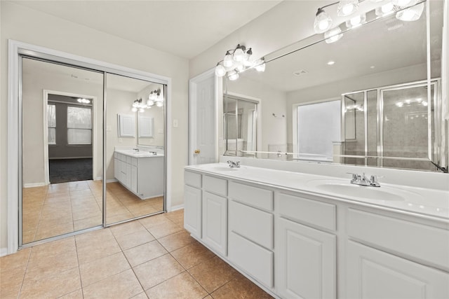 bathroom featuring vanity, a shower with shower door, and tile patterned floors