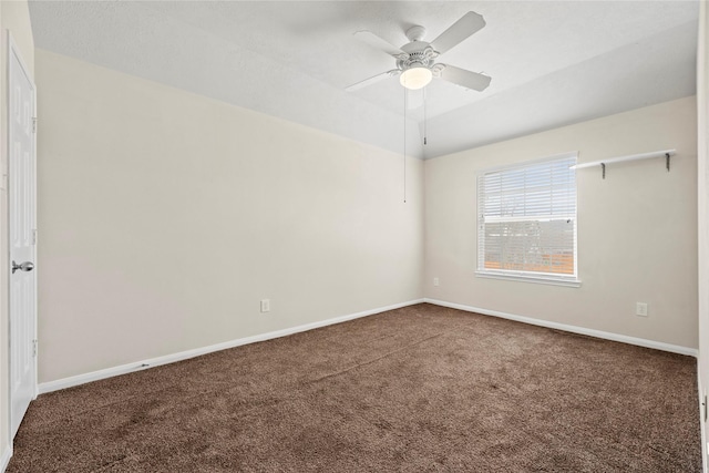 spare room with dark carpet and ceiling fan