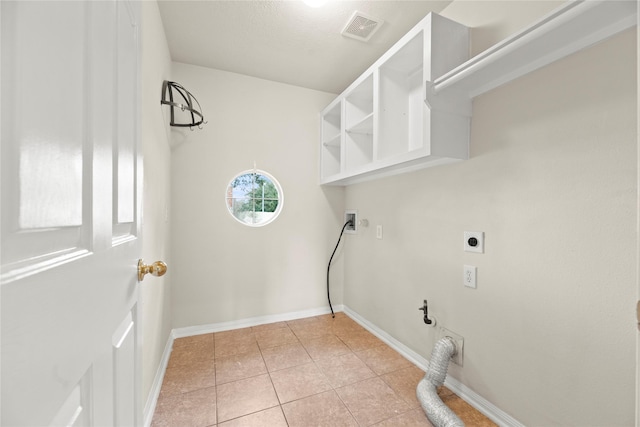 laundry room with hookup for an electric dryer and light tile patterned floors