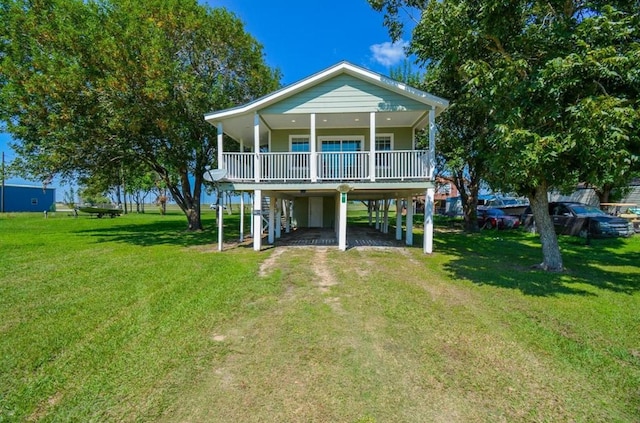 back of property with a yard, a carport, a porch, and driveway