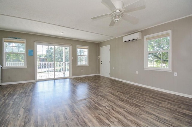 unfurnished room with an AC wall unit, plenty of natural light, wood finished floors, and crown molding