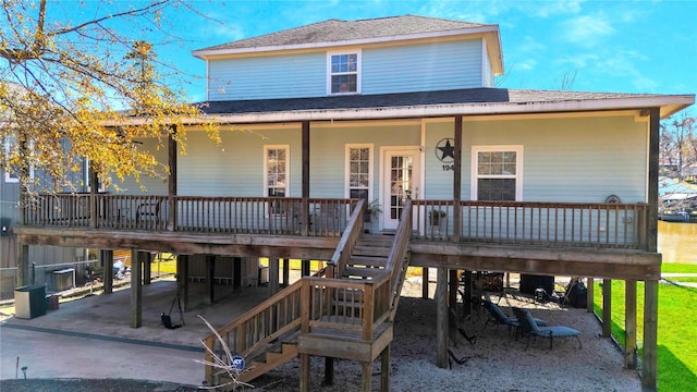 view of front facade with stairs, a carport, a porch, and a shingled roof