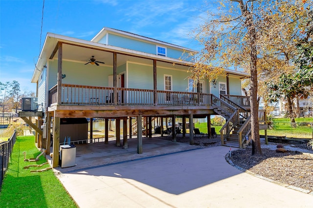 raised beach house with a porch, central AC, ceiling fan, a carport, and driveway