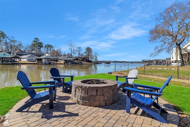 view of patio / terrace with a water view, an outdoor fire pit, a residential view, and fence