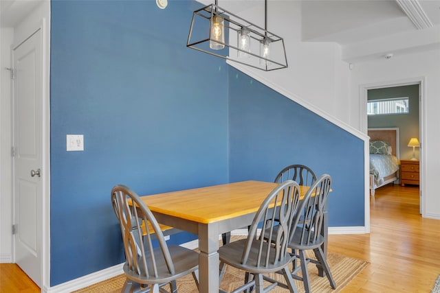 dining room featuring light wood-style flooring and baseboards