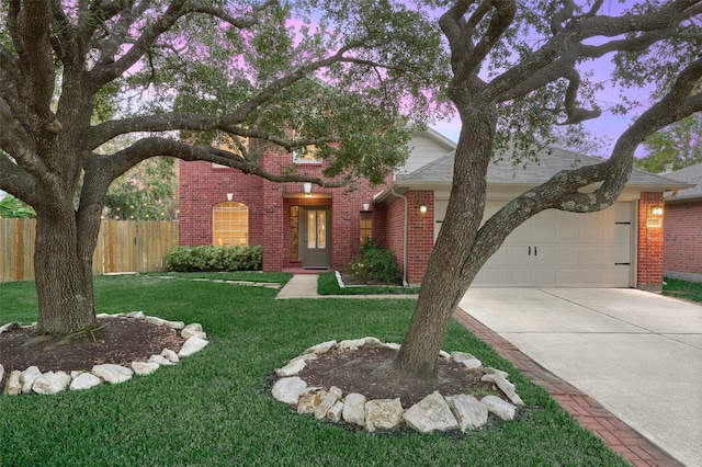 view of front of property with a garage and a lawn