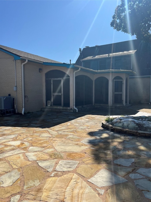 rear view of house featuring central AC, a patio, and brick siding