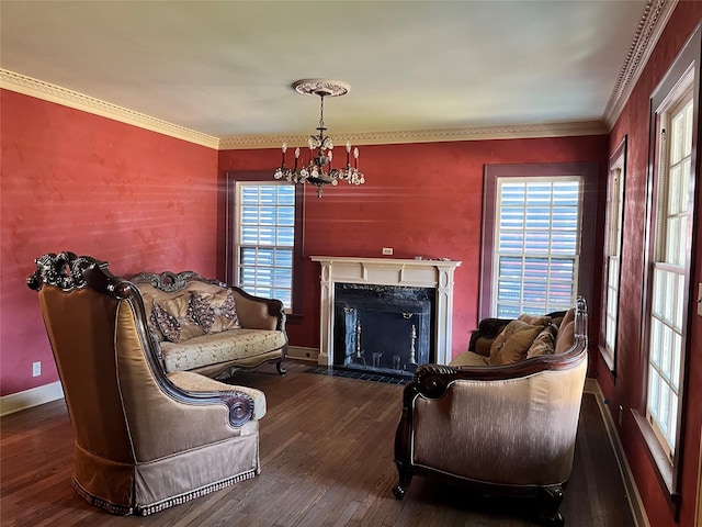 living area with a high end fireplace, baseboards, dark wood-style floors, an inviting chandelier, and crown molding