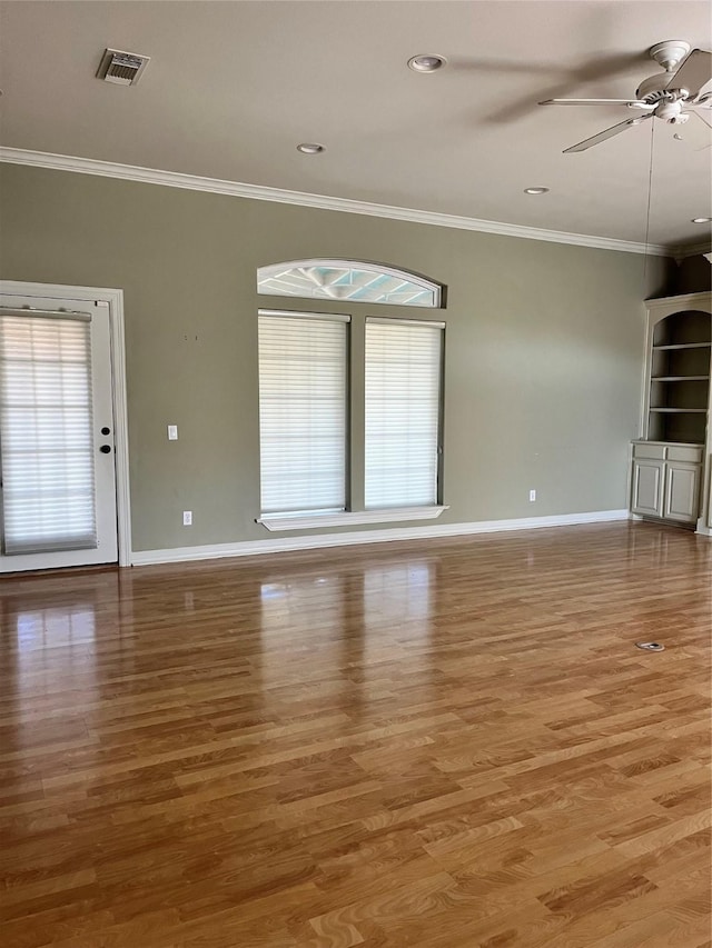 unfurnished living room featuring plenty of natural light, wood finished floors, and visible vents