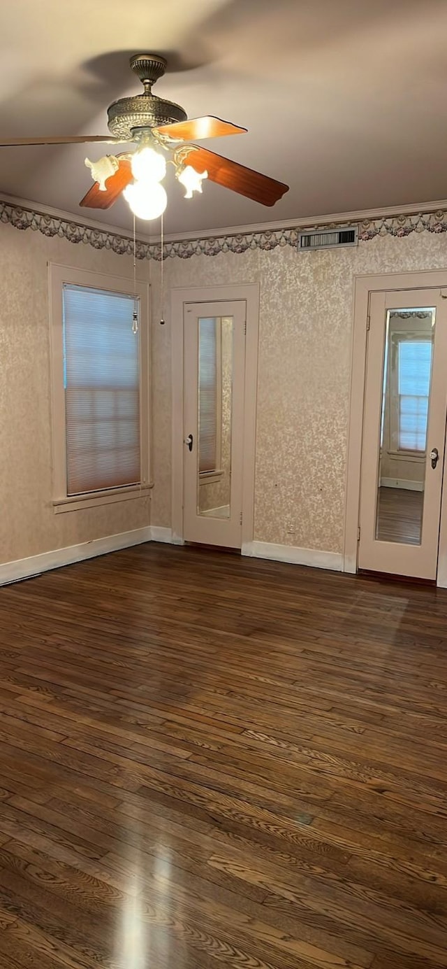 empty room featuring baseboards, dark wood-style flooring, visible vents, and a ceiling fan