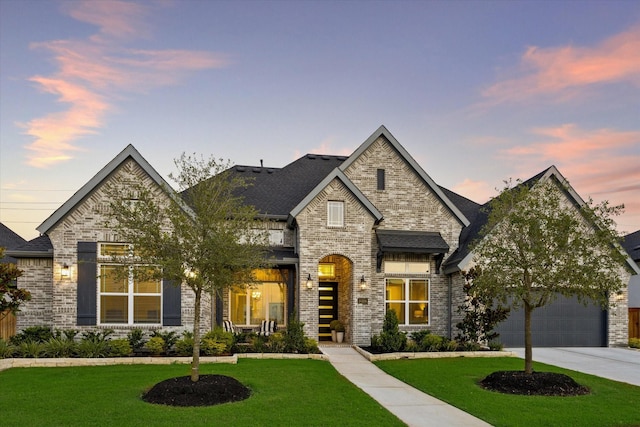 french country style house featuring a yard and a garage