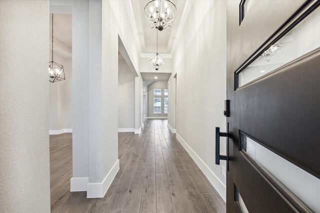 corridor featuring hardwood / wood-style floors and an inviting chandelier