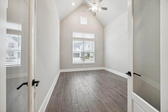 empty room featuring high vaulted ceiling, hardwood / wood-style floors, and ceiling fan