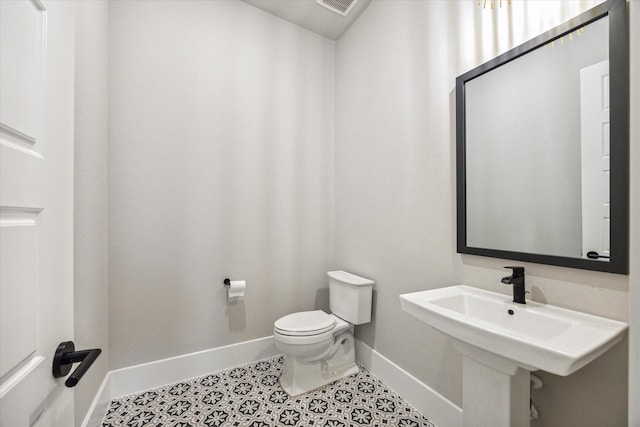 bathroom featuring sink, toilet, and tile patterned flooring