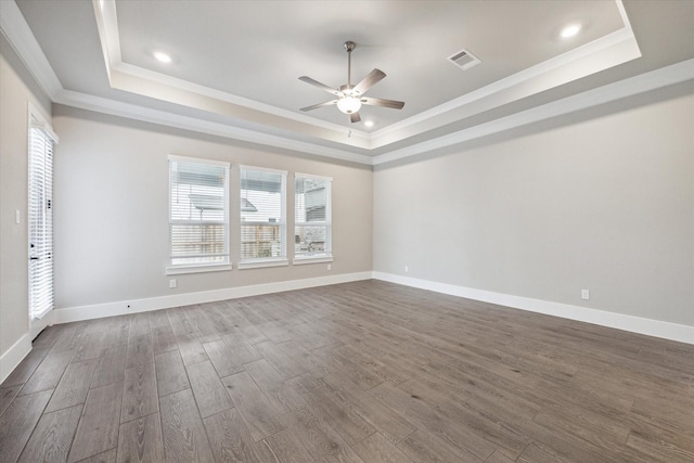 unfurnished room with crown molding, hardwood / wood-style floors, and a tray ceiling