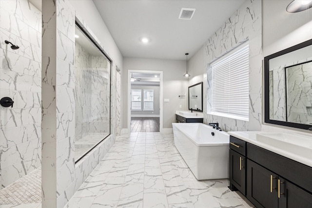 bathroom with vanity and shower with separate bathtub