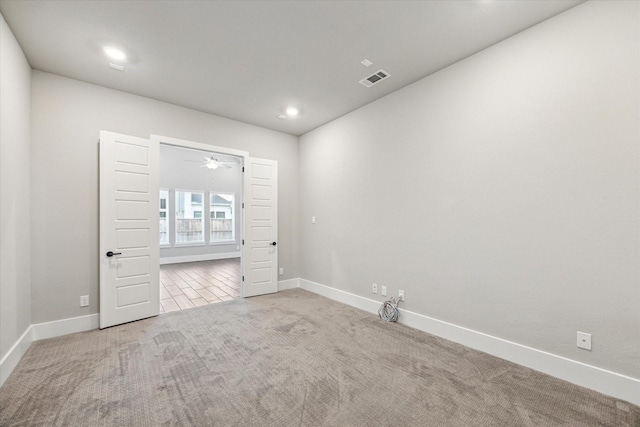 unfurnished room featuring light colored carpet and ceiling fan