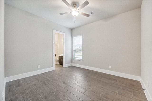 spare room featuring dark wood-type flooring and ceiling fan