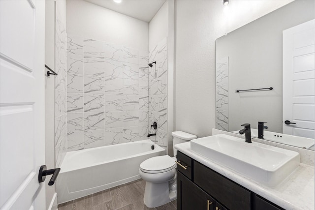 full bathroom with tiled shower / bath combo, vanity, hardwood / wood-style floors, and toilet