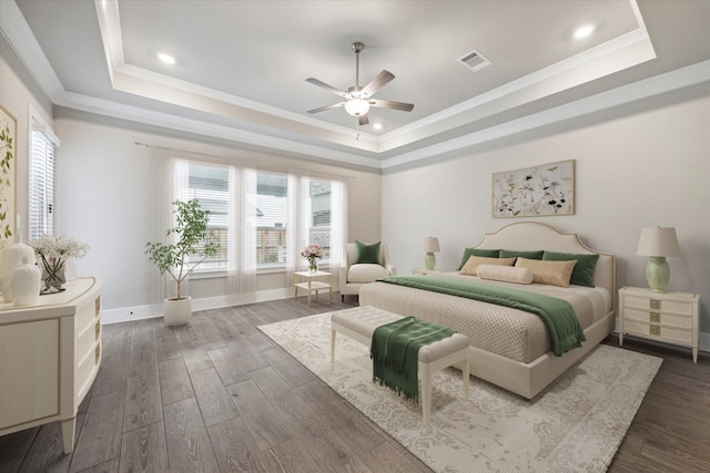 bedroom featuring a raised ceiling, ornamental molding, dark wood-type flooring, and ceiling fan