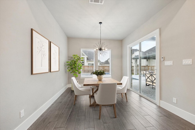 dining space with dark hardwood / wood-style flooring and a chandelier