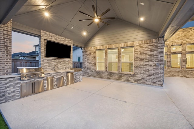 view of patio featuring area for grilling, ceiling fan, and exterior kitchen