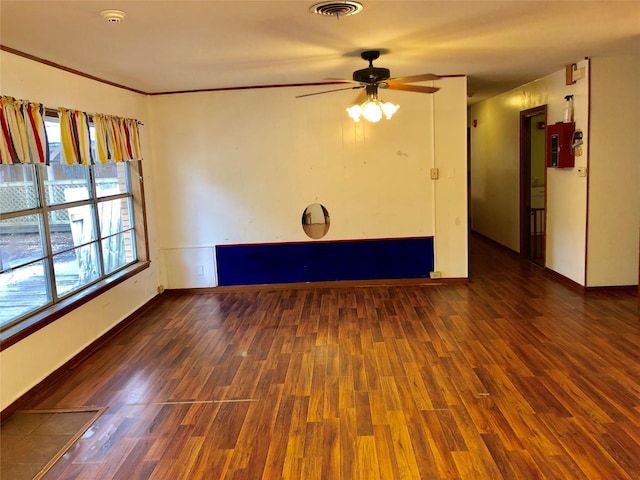 spare room featuring crown molding, dark hardwood / wood-style floors, and ceiling fan