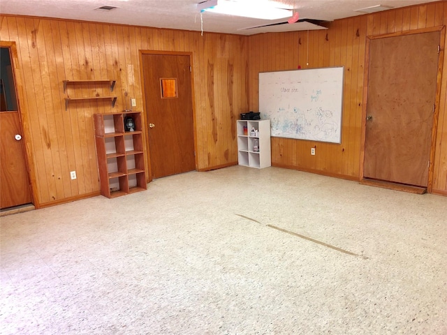 unfurnished living room with wood walls