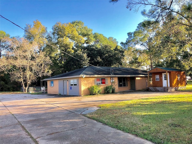 single story home featuring an outbuilding and a front yard