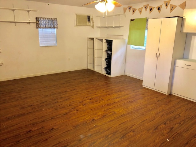 spare room with dark hardwood / wood-style floors, a wall mounted AC, and ceiling fan