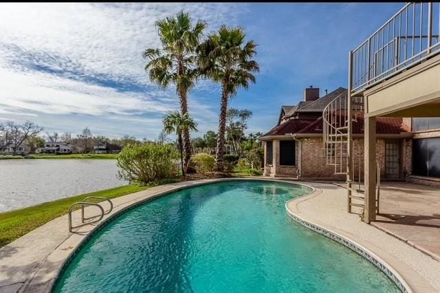 view of swimming pool featuring a patio area and a water view