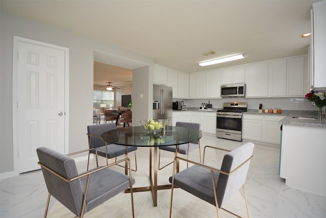 kitchen featuring white cabinetry, stainless steel appliances, sink, and backsplash