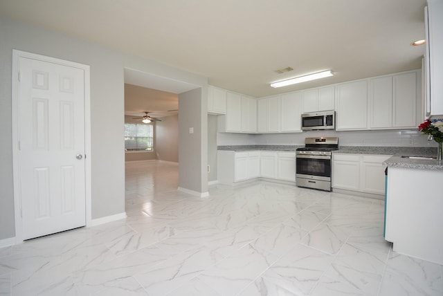 kitchen with sink, ceiling fan, stainless steel appliances, tasteful backsplash, and white cabinets