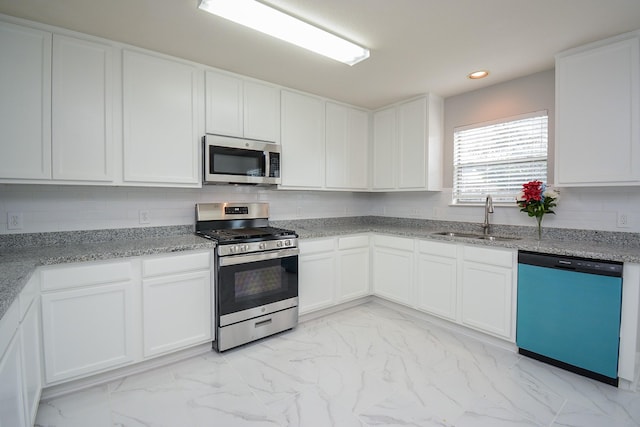 kitchen featuring white cabinetry, sink, backsplash, stainless steel appliances, and light stone countertops