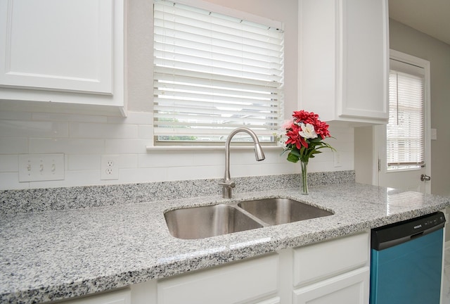 kitchen featuring white cabinetry, black dishwasher, sink, and light stone counters