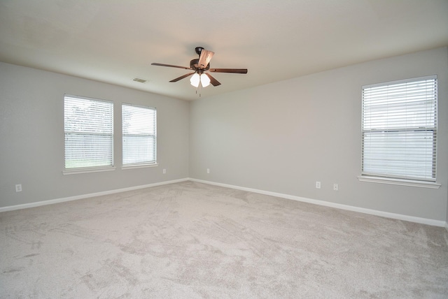 carpeted spare room with ceiling fan