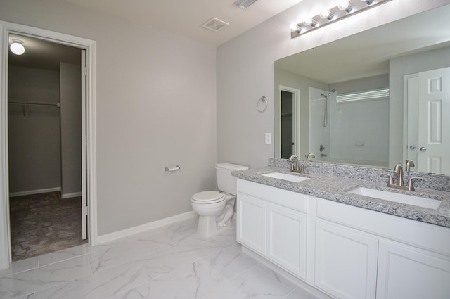 bathroom featuring tiled shower, vanity, and toilet